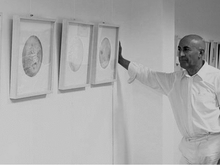Federico Osorio junto a una acuarela de la exposición "Cosmos"